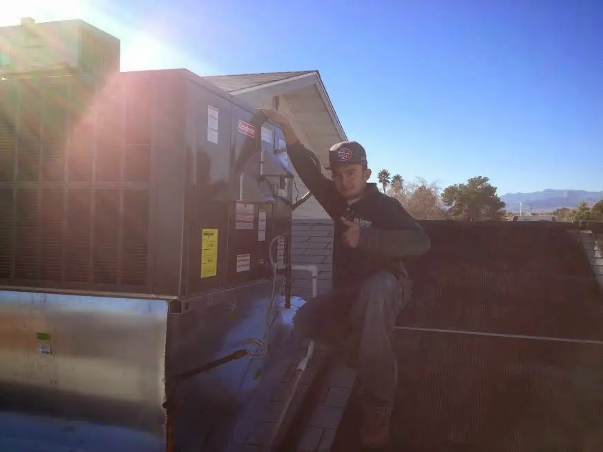 HVAC technician performing AC Tune-Up on a rooftop unit in Dentsville