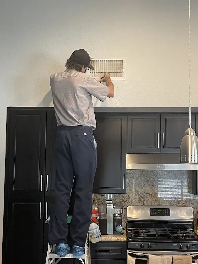 Technician inspecting an air vent during HVAC service in Dentsville